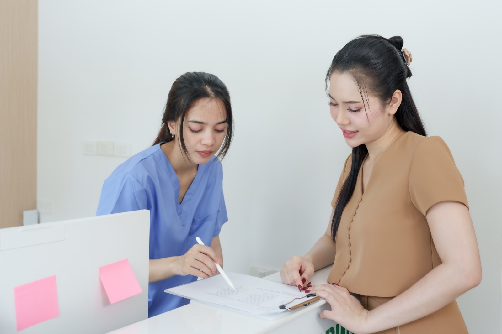 クリニックの受付で問診票を記入する様子（イメージ）